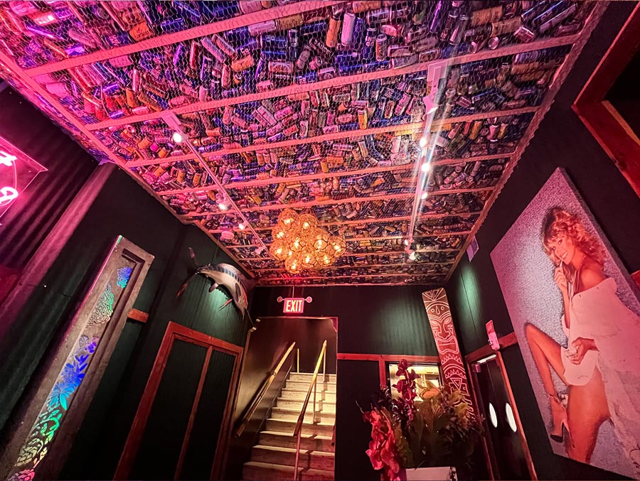 Hallway with artwork and ceiling of empty drink cans at a Tiki Bar in New York City NYC.